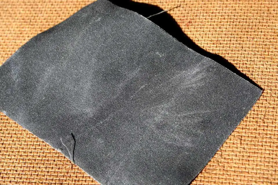 Use fine grit sandpaper for stubborn particles